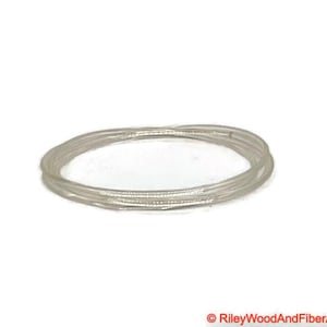 以下が含まれることがあります： 透明で細く柔軟なプラスチックコードの束で、円形に巻かれています。 コードは半透明でわずかに反射しており、滑らかな表面を示唆しています。 クラフトやジュエリー作りに使用される可能性があります。