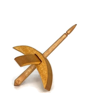 May include: A wooden spinning wheel with a crescent-shaped whorl and a spindle. The wheel is made of light brown wood and the spindle is made of a darker brown wood.