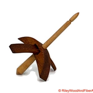 May include: A wooden spinning wheel with a brown and natural wood finish. The wheel has a single spindle and a curved base.