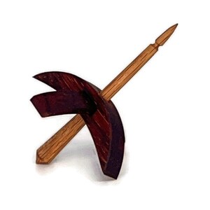 May include: A wooden spinning wheel with a dark brown base and a light brown spindle.