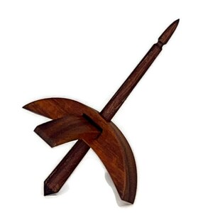 May include: A wooden spinning wheel with a dark brown finish. The wheel is made of two pieces of wood, one curved and one straight. The straight piece is attached to the curved piece at a right angle. The wheel is designed to be used for spinning yarn.