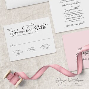 May include: A white RSVP card with black text. The card has a section for the guest to accept or decline the invitation, and a space to indicate the number of people attending. The text on the card reads "November First, Two Thousand Nineteen".