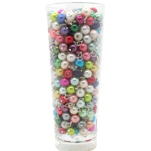May include: A clear glass vase filled with a variety of colourful pearl beads. The beads are in shades of pink, blue, green, purple, and white.