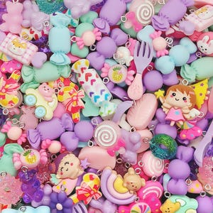 May include: A collection of colorful charms featuring candy, food, and cartoon characters. The charms are made of plastic and have a glossy finish. They are perfect for adding a touch of whimsy to jewelry, keychains, or other crafts.