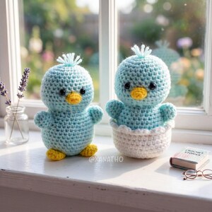 Puede incluir: Dos juguetes de p&aacute;jaros azules hechos a mano con ganchillo, con picos y patas amarillas. Un p&aacute;jaro est&aacute; solo, el otro est&aacute; sentado en una huevera de ganchillo blanca. Los juguetes tienen ojos negros y un mech&oacute;n de hilo azul en la cabeza.
