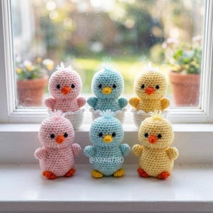 Puede incluir: Seis pollitos de ganchillo hechos a mano en colores pastel: rosa, azul y amarillo. Cada pollito tiene pico y patas naranjas y est&aacute; sentado en una c&aacute;scara de huevo blanca. Los pollitos se exhiben en un alf&eacute;izar blanco.