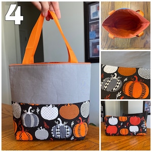 May include: A gray and orange tote bag with a pumpkin pattern. The bag has two orange handles and a gray lining. The bag is sitting on a wooden surface.