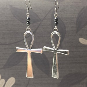 May include: Silver Ankh earrings with black beads. The Ankh is an ancient Egyptian symbol of life.