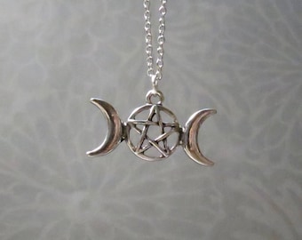 Könnte beinhalten: Silberne Halskette mit einem dreifachen Mond- und Pentagramm-Anhänger. Der Anhänger ist ein Symbol für die drei Mondphasen und die fünf Elemente.