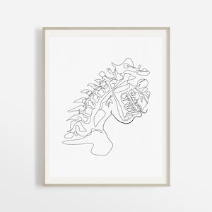 May include: Line art drawing of a human spine in a single continuous line. The spine is depicted in a stylized, abstract manner, with the vertebrae and ribs represented by flowing lines.
