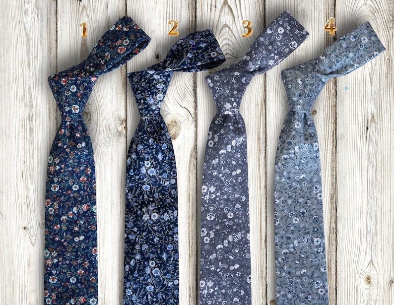 May include: Four different patterned neckties in shades of blue and white. The ties are arranged in a row, with the numbers 1 through 4 printed above each tie.