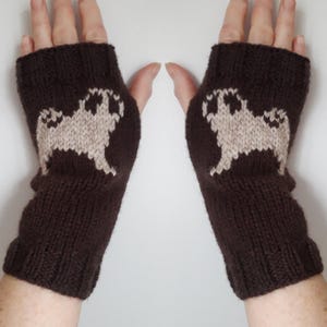 May include: A pair of brown fingerless gloves with a white pug design knitted into each glove.