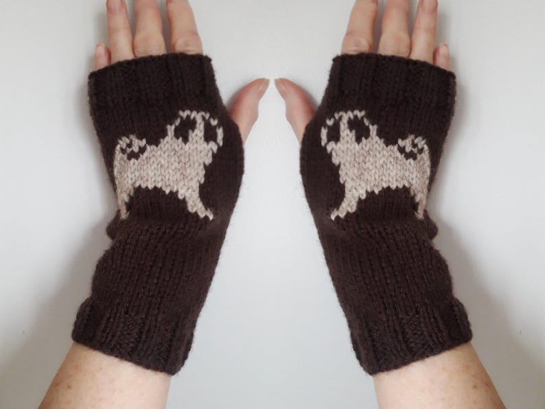 May include: A pair of brown fingerless gloves with a white pug design knitted into each glove.