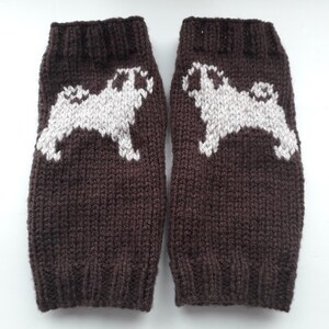 May include: A pair of brown knitted leg warmers with white pug dog designs.