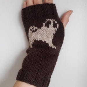 May include: Brown knitted fingerless gloves with a beige pug design.