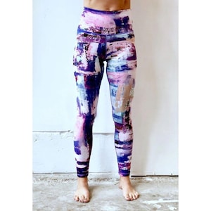 May include: Purple, pink, and blue abstract print leggings with a high waist.