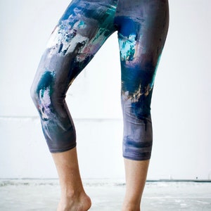 May include: A pair of cropped leggings with an abstract print featuring shades of blue, gray, and white.