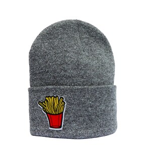 Könnte beinhalten: Graue Strickmütze mit einem roten und gelben Pommes-Frites-Aufnäher.
