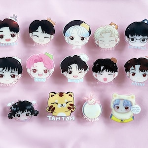 May include: A set of 12 colourful cartoon character pins featuring various characters with different hairstyles and expressions. The pins are made of clear acrylic and have a glossy finish. The characters are all wearing different outfits and accessories. The pins are perfect for adding a touch of personality to your clothing, bags, or backpacks.