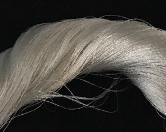 May include: A bundle of white, silky, and delicate threads. The threads are tightly woven together and have a soft, lustrous sheen.
