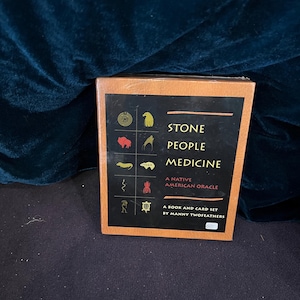 May include: A boxed set titled "STONE PEOPLE MEDICINE: A NATIVE AMERICAN ORACLE" by Manny Twofeathers. The box is brown with a black and orange label featuring various symbols. The set includes a book and card set.