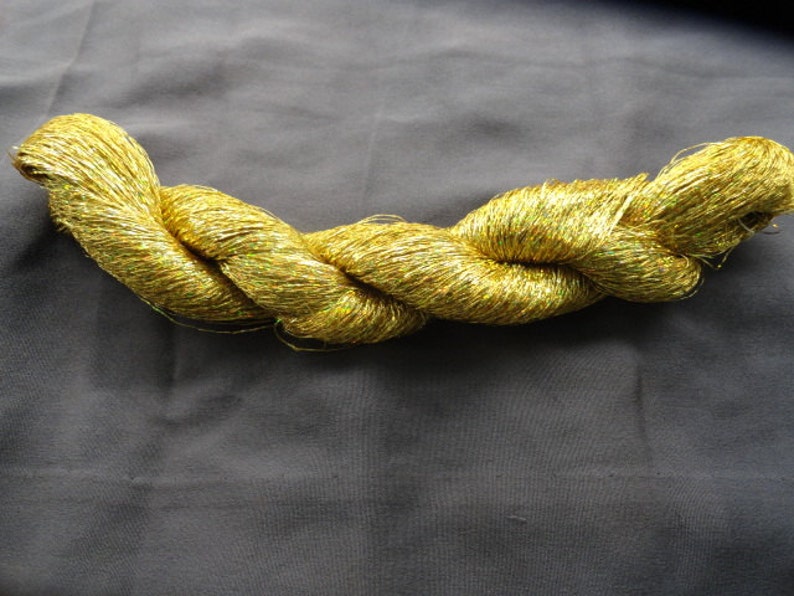 May include: A spool of gold metallic yarn with a shimmery finish.