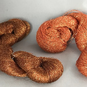 May include: Two spools of metallic copper thread, one is a darker copper color and the other is a lighter copper color.