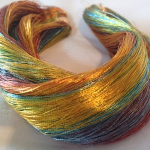 May include: A bundle of metallic thread in shades of gold, copper, teal, and blue. The thread is arranged in a loose coil.