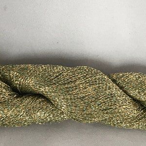 May include: A skein of metallic green yarn with gold shimmer.