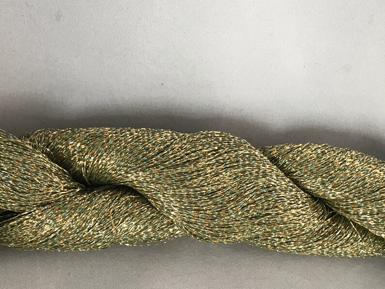 May include: A skein of metallic green yarn with gold shimmer.