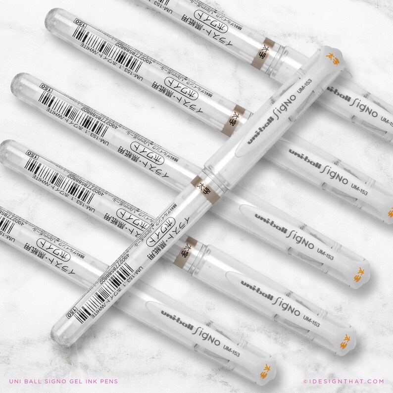 May include: Several white Uni-ball Signo UM-153 gel ink pens are displayed. Each pen features a clear barrel, white body, and a cap with Japanese text. The pens are arranged on a light surface. The text "UNI BALL SIGNO GEL INK PENS" is at the bottom.