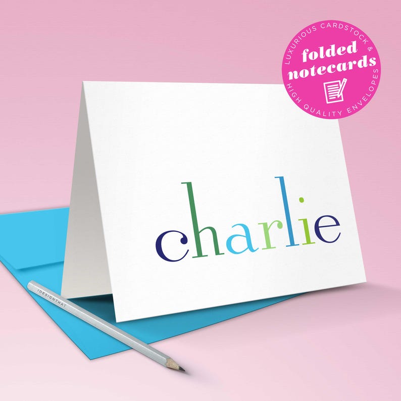 A folded rainbow note card displayed upright shows the premium cardstock of this kids stationary set of colorful thank you cards.