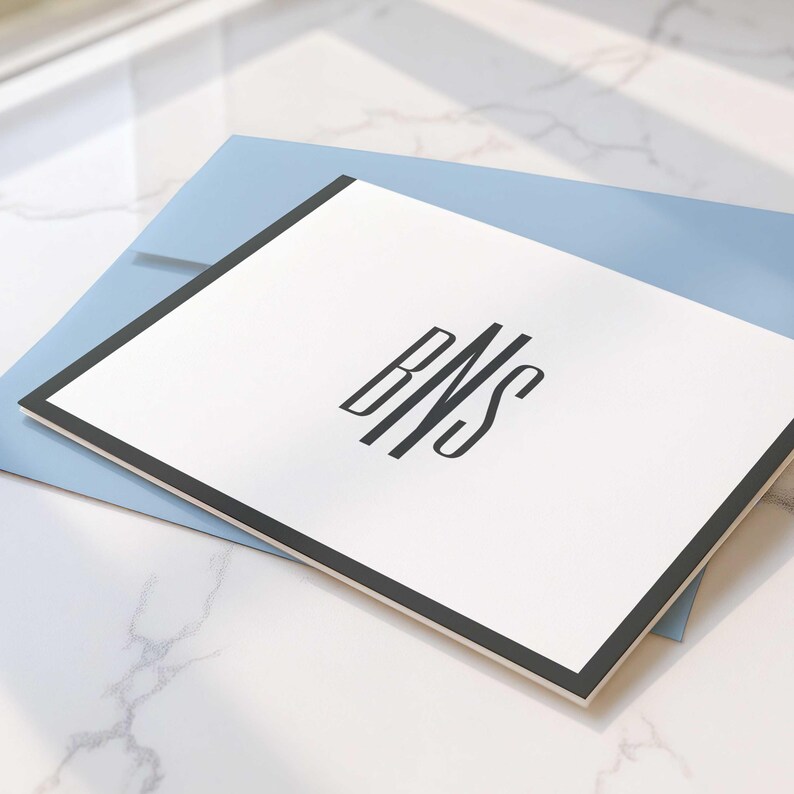 Monogram stationery featuring a larger last-name initial between two smaller initials on folded A2 cards.