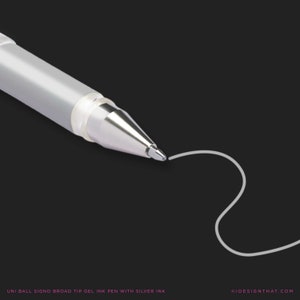 May include: A close-up shot of a silver and translucent gel ink pen with a broad tip, drawing a white line on a black backdrop. The pen is labelled "UNI BALL SIGNO BROAD TIP GEL INK PEN WITH SILVER INK".