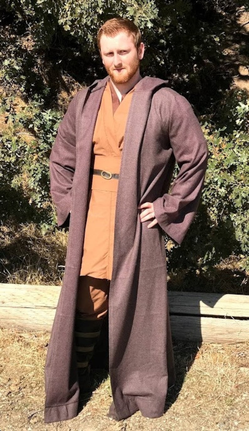 May include: A person wearing a brown hooded robe with a brown belt and a brown undershirt. The robe has a long, flowing design and is made of a soft, comfortable fabric.