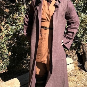 May include: A brown hooded robe with a brown belt and a brown undershirt. The robe is made of a soft, textured fabric.