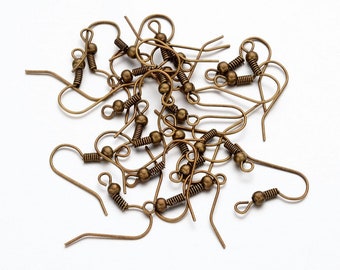 May include: A pile of bronze-colored earring hooks with a small ball at the top of each hook.