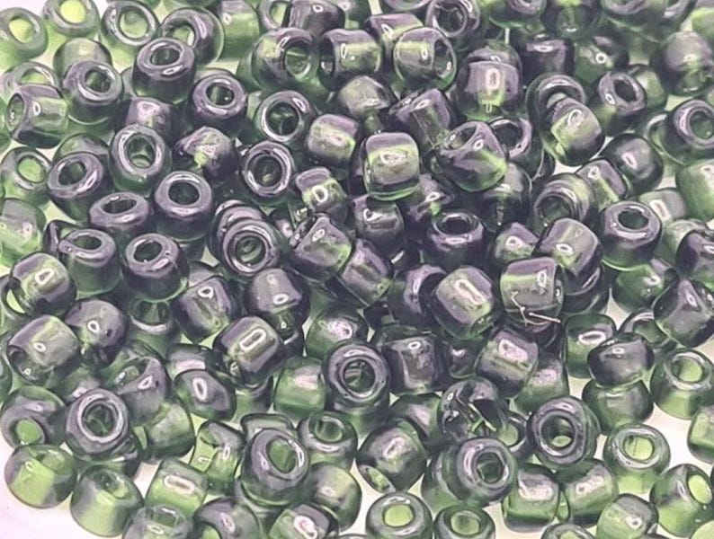 Pode incluir: Uma grande quantidade de contas de sementes de vidro verde escuro. As contas s&atilde;o opacas e t&ecirc;m um acabamento ligeiramente iridescente.