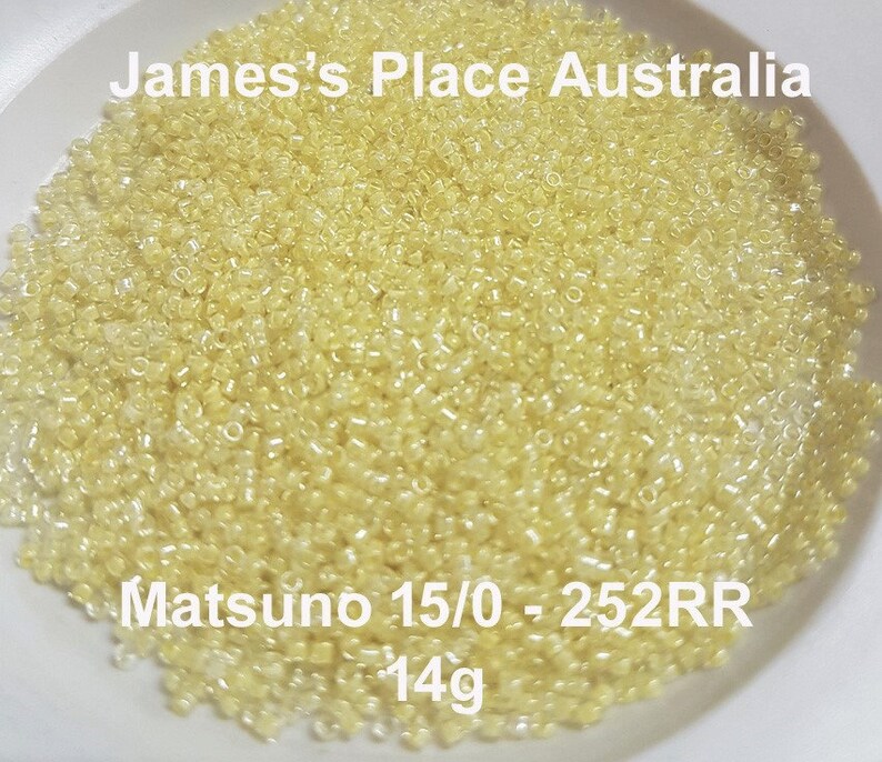 May include: A close-up image of a bowl filled with small, translucent yellow beads. The beads are labeled "Matsuno 15/0 - 252RR - 14g".