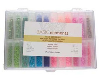 May include: A clear plastic storage box with 24 compartments filled with various colours of small glass seed beads. The box has a label that reads "BASICelements™ Glass Seed Beads Perles de Rocaille Envers Mostacillas de Vidrio Assorted Colors", with a description of the beads and their size.