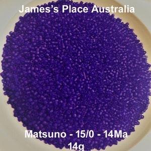 May include: A close-up of a bowl filled with small, round, purple beads. The beads are labeled "Matsuno - 15/0 - 14Ma 14g".