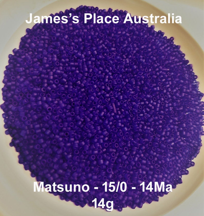 May include: A close-up of a bowl filled with small, round, purple beads. The beads are labeled "Matsuno - 15/0 - 14Ma 14g".