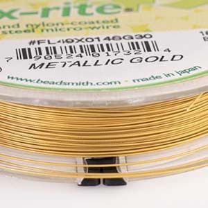 Peut inclure: Une bobine de fil métallique micro-câble en acier recouvert de nylon de couleur or. L'étiquette indique "#FL40X0146G30" et "METALLIC GOLD". La bobine est fabriquée au Japon.