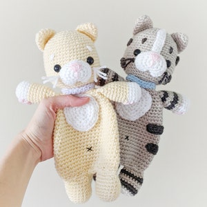 May include: Two crocheted cat toys. One is yellow with white accents and the other is gray with black stripes.