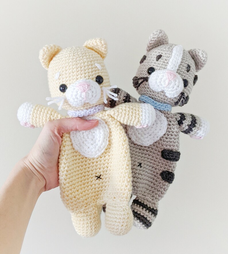 May include: Two crocheted cat toys. One is yellow with white accents and the other is gray with black stripes.