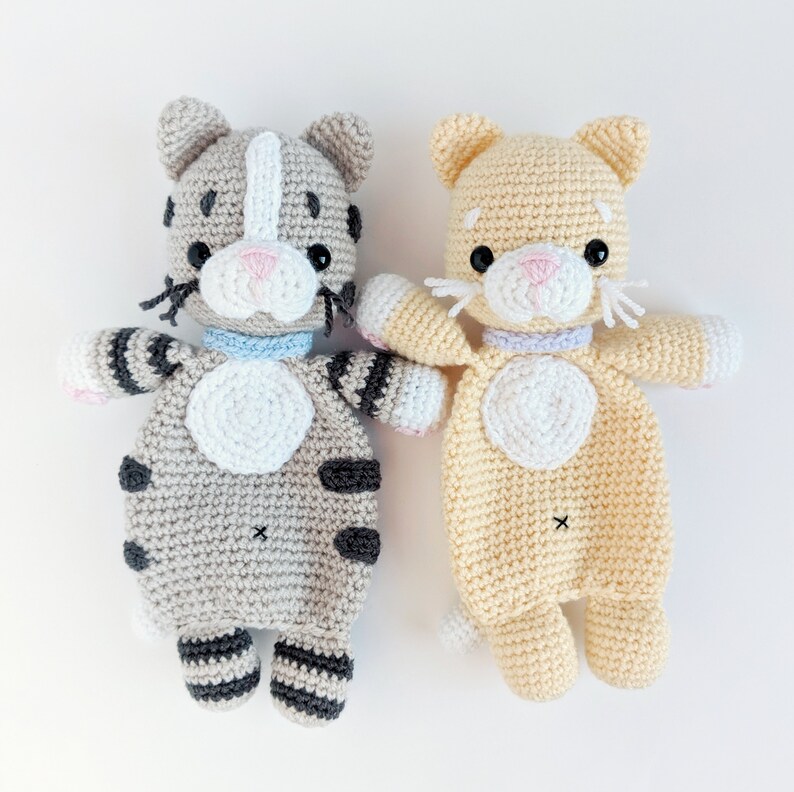 May include: Two crocheted cat toys, one gray and one yellow. Both have white accents and black eyes. They are made with a soft yarn and have a sweet, cuddly look.