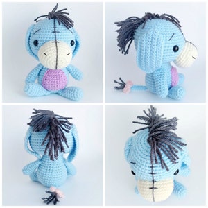 May include: A blue crocheted stuffed donkey with a black mane and tail. The donkey has a white face with black eyes and a pink nose. The donkey is sitting on a white background.