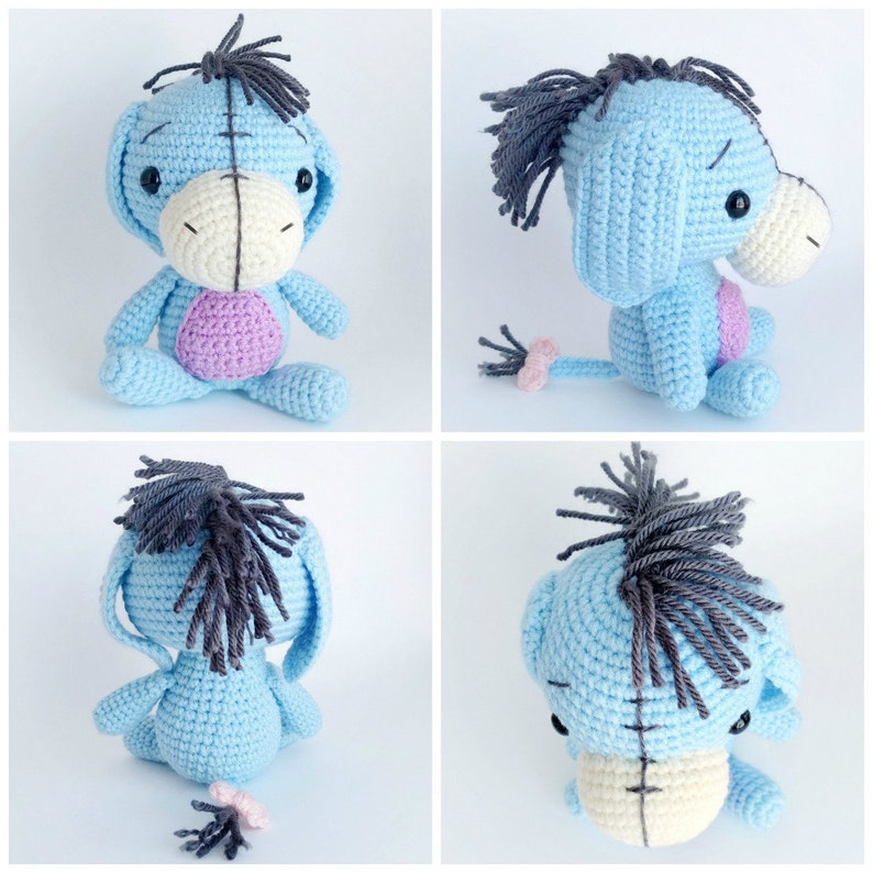 May include: A blue crocheted stuffed donkey with a black mane and tail. The donkey has a white face with black eyes and a pink nose. The donkey is sitting on a white background.