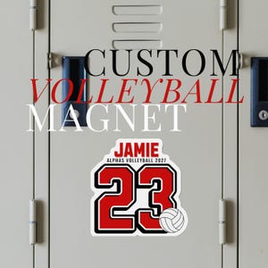 May include: A custom volleyball magnet featuring the name JAMIE in red, the text ALPHAS VOLLEYBALL 2027 in black, and the large red number 23 with a black outline. A small white volleyball graphic is positioned next to the number 23.