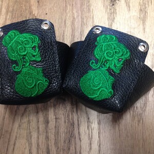 Protezioni per la punta dei pattini da roller derby in pelle con cammeo a forma di teschio verde.